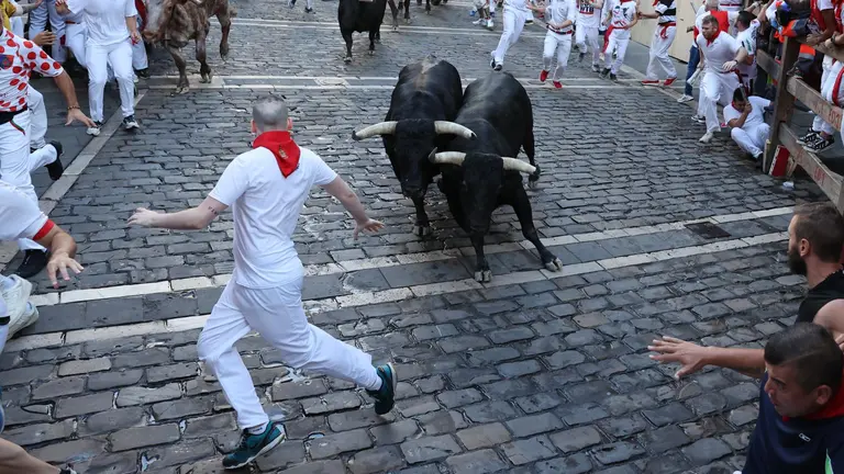 Los mozos, durante del séptimo encierro de los sanfermines con toros de la ganadería de Victoriano del Río y dos minutos y 18 segundos de duración, este jueves en Pamplona EFE/Villar López