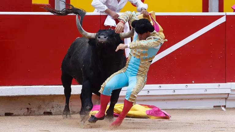 El diestro Rubén Pinar sufre una cogida durante la lidia al primer toro de la tarde en la última corrida de abono de la Feria del Toro de los Sanfermines 2023, con toros de la ganadería sevillana de Miura, donde ha compartido cartel con Rubén Pinar y Juan Leal. EFE/ Rodrigo Jiménez