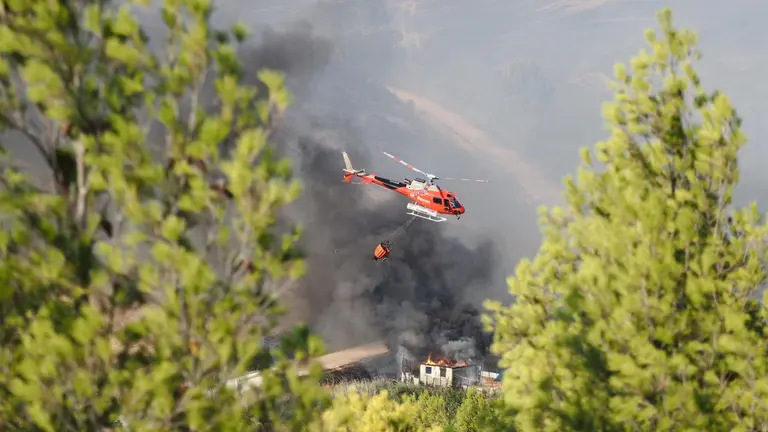 Un helicóptero trabaja en las tareas de extinción del incendio forestal declarado el jueves por la tarde en Artajona (Navarra). - EDUARDO SANZ-EUROPA PRESS