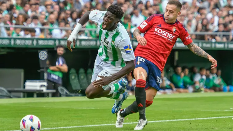 El delantero del Real Betis Assane Diao (i) disputa una posesión ante Moi Gomez, centrocampista de Osasuna, durante el partido jugado en el estadio Benito Villamarín de Sevilla. EFE/ Raúl Caro.