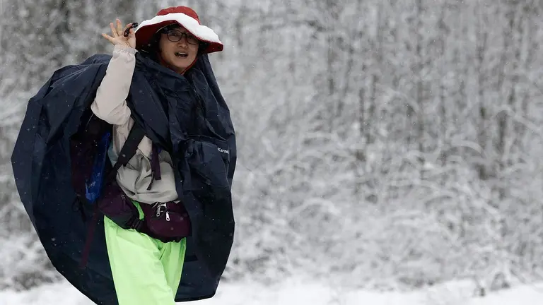 Un grupo de peregrinos coreanos realizan su camino por la carretera ante la imposibilidad de hacerlo por el camino original por la presencia de nieve en una jornada donde la normalidad es la nota dominante en las carreteras navarras a primeras horas de este miércoles en el que la Comunidad Foral está en alerta por nevadas. Así, tan solo son necesarias las cadenas para circular por la NA-137 Burgui-Isaba-Francia, puerto de Belagua, desde el kilómetro 51, desde el refugio. EFE/ Jesús Diges