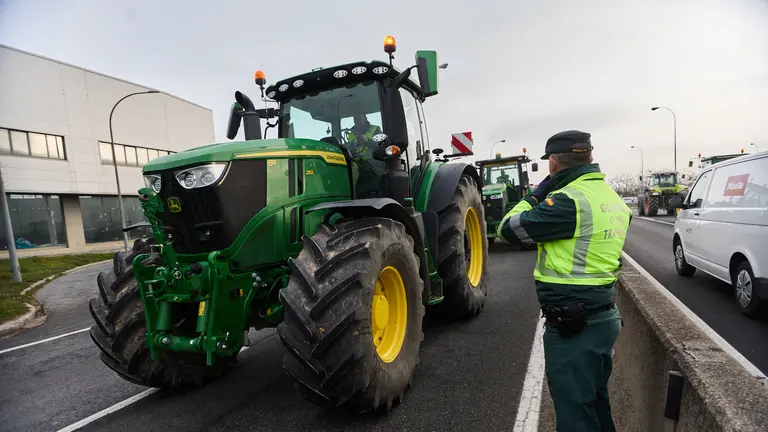 Un agente de la Guardia Civil ante uno de los tractores que participa en las protestas. IÑIGO ALZUGARAY