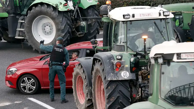 La movilización que los agricultores están llevando a cabo con sus tractores desde primeras horas en las vías principales de la Comunidad Foral están ocasionando retenciones en los accesos y salidas de Pamplona. Las retenciones han sido especialmente importantes en hora punta al encontrarse las rondas de la comarca ocupadas por los tractores, que no han entrado en la ciudad. Agentes de la Policía Municipal, Guardia Civil y Policía Foral regulan el tráfico e intensifican sus esfuerzos para evitar que se colapsen las zonas hospitalarias.EFE/ Jesús Diges