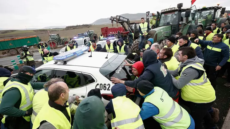 Agricultores mueven coches de la Guardia Civil para acceder a Pamplona este jueves. EFE