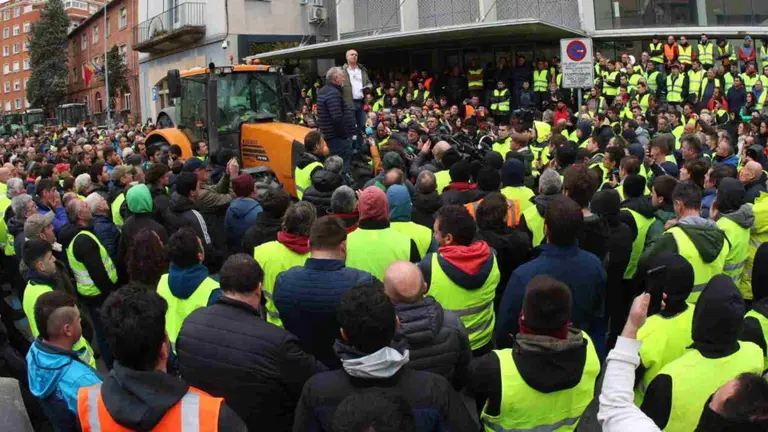 Sobre un tractor, los responsables informan al resto de los agricultores a la salida de la reunión. ÍÑIGO ALZUGARAY