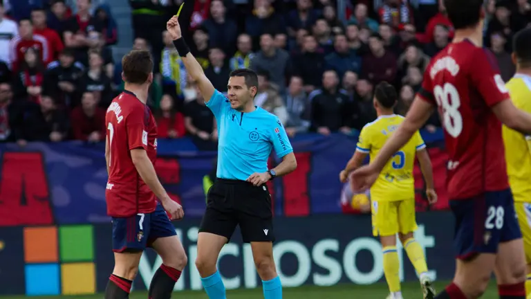 Francisco José Hernández Maeso muestra una tarjeta amarilla a Aimar Oroz en el partido entre CA Osasuna y Cádiz CF disputado en el estadio de El Sadar. IÑIGO ALZUGARAY