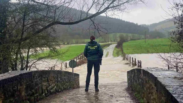 Una agente de la Guardia Civil contempla el río desbordado en una localidad navarra. GUARDIA CIVIL