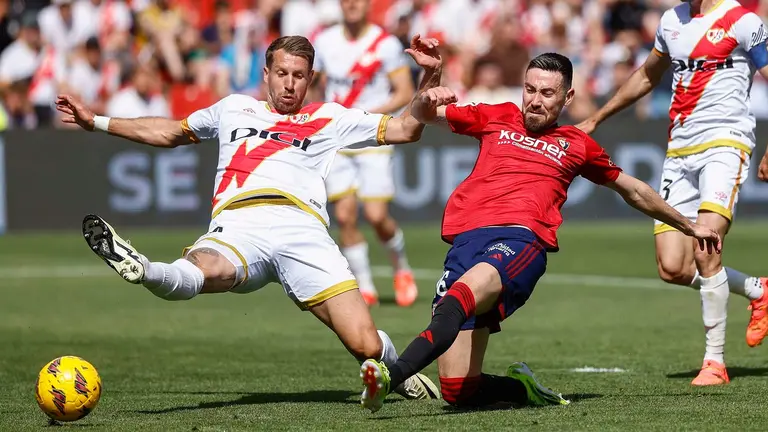 El centrocampista del Osasuna Moi Gómez (d) marca un gol ante la defensa del francés del Rayo Vallecano Florian Lejeune este sábado, durante el partido de la jornada 32 de LaLiga EA Sports, en el Estadio Vallecas de Madrid. EFE/ Rodrigo Jiménez