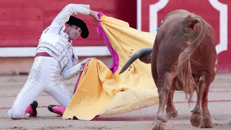 El diestro Fernando Adrián recibe con el capote a su primer toro de la tarde en la tercera de abono de la Feria de Toro de los Sanfermines 2024. EFE/Jesús Diges