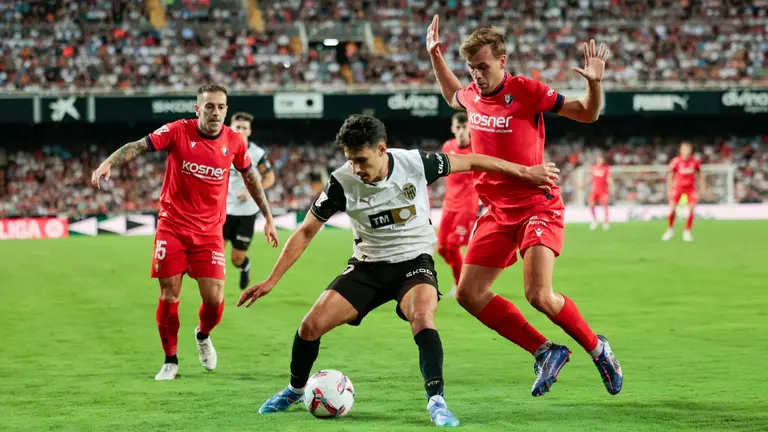 El centrocampista del Valencia CF André Almeida (c) junto al centrocampista del Osasuna Ibáñez (d) durante el encuentro correspondiente a la séptima jornada de LaLiga EA Sports que enfrenta al Valencia CF y al Osasuna en el estadio de Mestalla en Valencia, este martes. EFE/ Biel Aliño