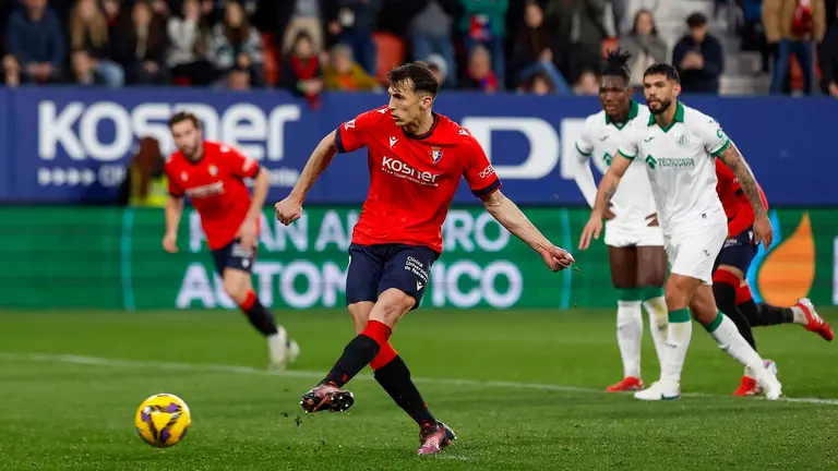 El delantero croata de Osasuna, Ante Budimir, golpea el balón desde el punto de penalti para conseguir el primer gol del equipo navarro durante el encuentro correspondiente a la jornada 28 de Laliga EA Sports que disputan hoy domingo Osasuna y Getafe en el estadio El Sadar, en Pamplona. EFE / Villar López.