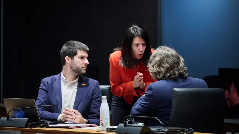 La parlamentaria de Geroa Bai Itxaso Soto haboa con los parlamentarios de Contigo Navarra Carlos Guzmán y Daniel López durante el pleno del Parlamento. PABLO LASAOSA