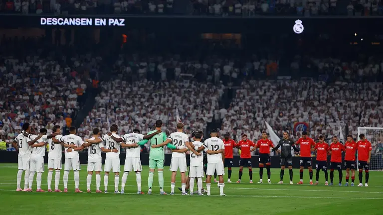 Los jugadores del Real Madrid y de Osasuna guardan un minuto de silencia por los socios fallecidos en la temporada pasada, por los fallecidos en los incendios forestales y por Javier Lambán, antes de comenzar el partido de la primera jornada de LaLiga que Real Madrid y Atlético Osasuna disputan hoy martes en el estadio Santiago Bernabéu. EFE/Mariscal
