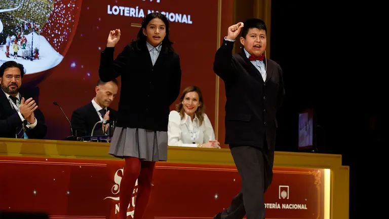 Aisha Solange (i) y Gorka Calderón (d), cantan un cuarto premio, el 78.477, que ha sido agraciado con un cuarto premio en el Sorteo de la Lotería de Navidad y dotado con 200.000 euros a la serie (20.000 euros al décimo). EFE/Chema Moya