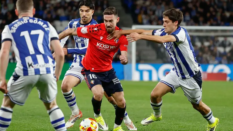 Moi Gómez intenta escaparse de los jugadores de la Real Sociedad, durante el encuentro correspondiente a los octavos de final de la Copa del Rey que disputaron Real Sociedad y Osasuna en el estadio de Anoeta. EFE/ Javier Etxezarreta.