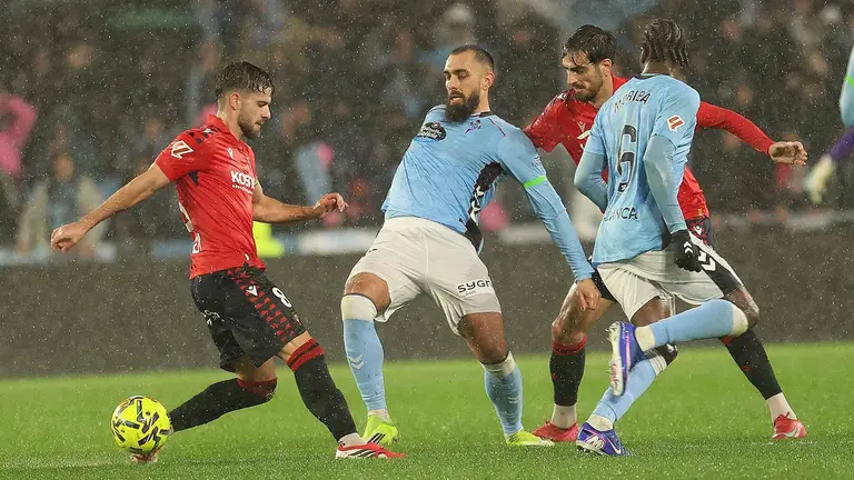 El delantero del Celta Borja Iglesias (2-i) pelea un balón con Iker Muñoz (i), de Osasuna, durante el partido de LaLiga que Celta de Vigo y CA Osasuna disputan este viernes en el estadio de Balaídos. EFE/Salvador Sas
