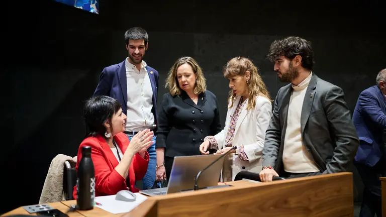 Laura Aznal, de EH Bildu, habla con Carlos Guzmán, de Contigo Navarra, y con parlamentarios del PSN durante el Pleno del Parlamento de Navarra. PABLO LASAOSA