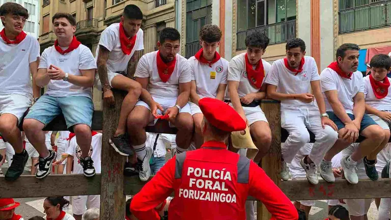 Un policía Foral se dirige a unos jóvenes subidos en el vallado equivocado. PATXI CERVANTES