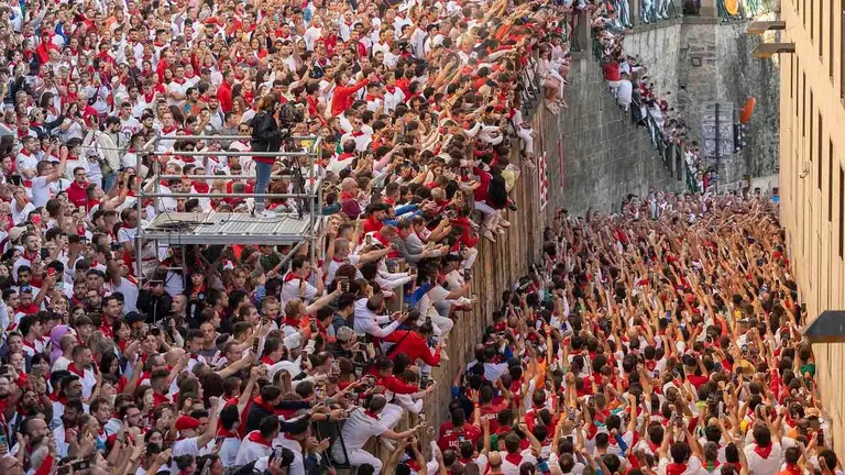 Corredores entonan el cántico ante la hornacina a San Fermín de la cuesta de Santo Domingo de Pamplona en los momentos previos al encierro. EFE/ Villar López