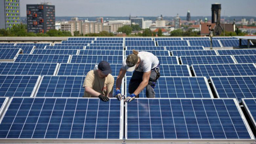 Operarios instalando paneles solares en el tejado de un edificio, cuyo uso para el autoconsumo. EFE