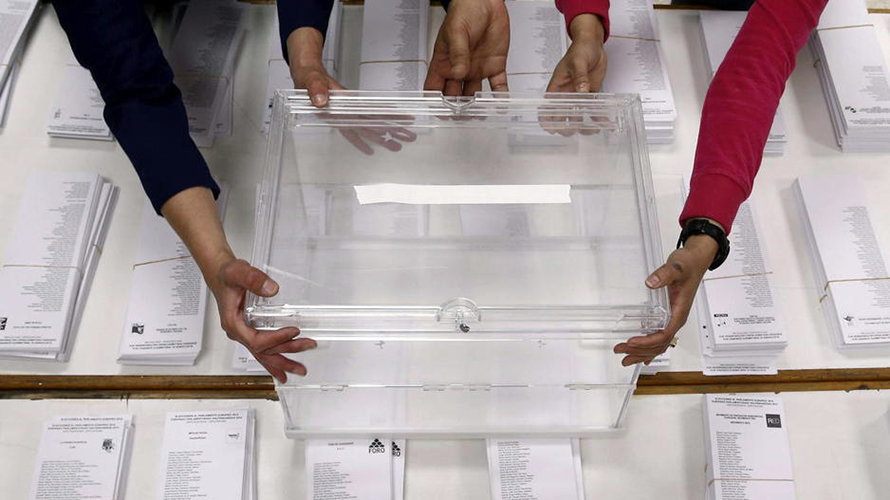 Varias personas colocan una urna en las pasadas elecciones.