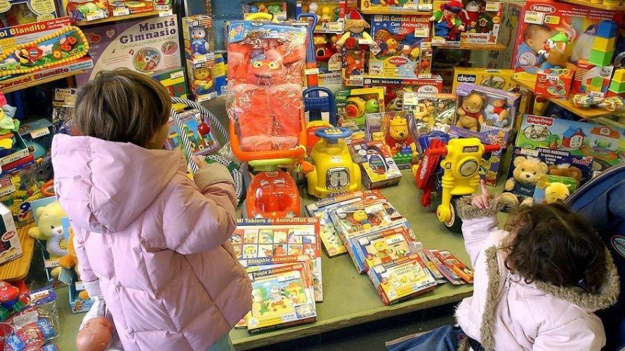 Dos niñas observan un escaparate lleno de juguetes. (Villar López, EFE)