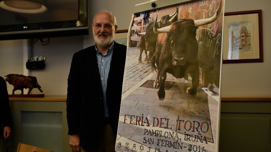 El pamplonés Pío Guerendiáin posa con el cartel de la Feria del Toro de San Fermín 2016. PABLO LASAOSA
