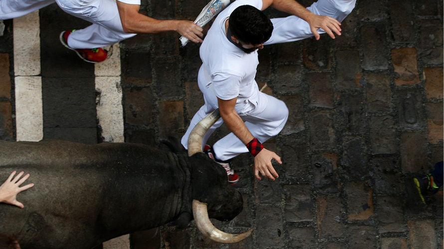 Un mozo corriendo delante de los toros de José Escolar en la calle Estafeta. REUTERS (7)