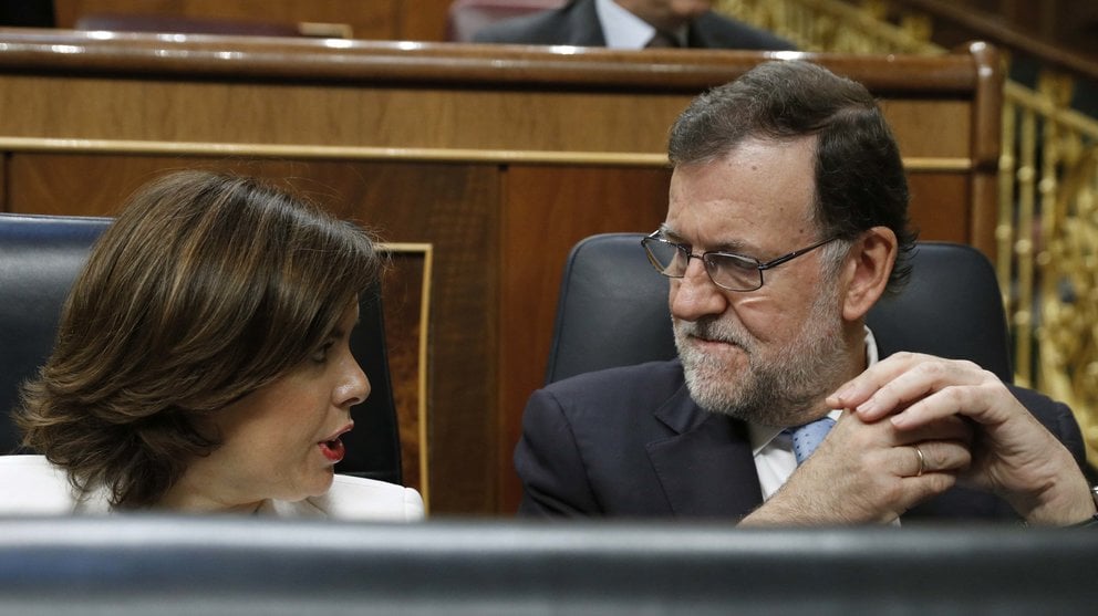 El presidente del Gobierno en funciones, Mariano Rajoy, y la vicepresidenta, Soraya Sáenz de Santamaría, conversan en su escaño hoy momentos antes de la sesión constitutiva de las Cortes Generales de la XII Legislatura. EFE/Ballesteros