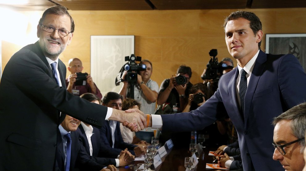 El jefe del Gobierno, Mariano Rajoy,iz., y el líder de Ciudadanos, Albert Rivera, se estrechan la mano durante la reunión de sus respectivas delegaciones en la que van a certificar el acuerdo de investidura.EFE/Sergio Barrenechea