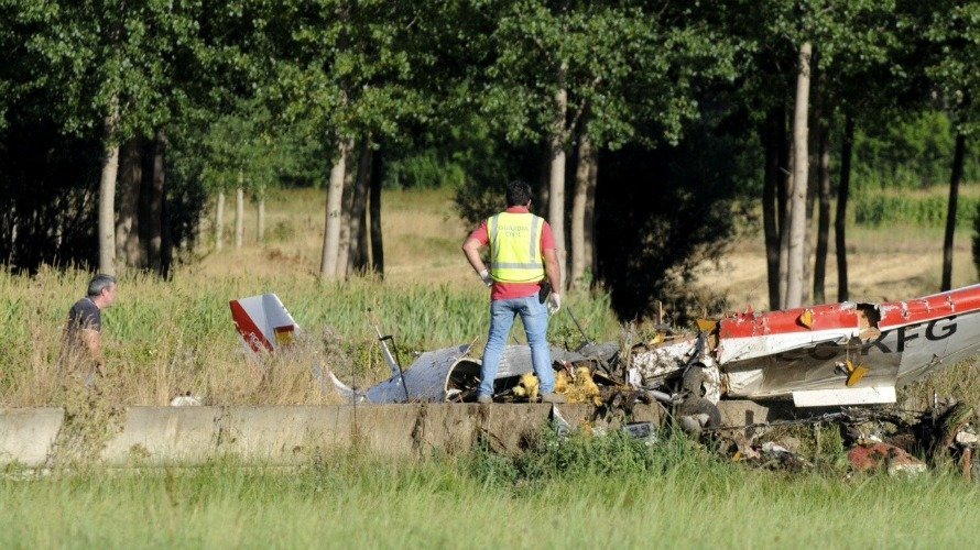 Dos guardias civiles investigan los restos de la avioneta que esta tarde se ha estrellado en una finca situada en las proximidades del Villanueva del Condado (León). EFE. CASARES
