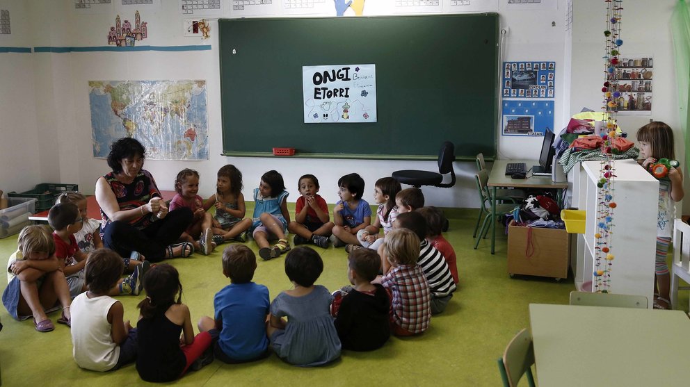 Una profesora da la bienvenida a sus alumnos en el interior de una clase del colegio Bernart Etxepare, en el barrio de la Rochapea, donde los alumnos de Infantil y Primaria. EFE/Jesús Diges