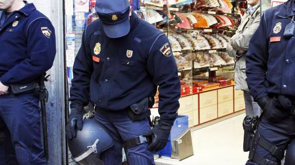 Un agente de la Policía Nacional controla un comercio. EFE