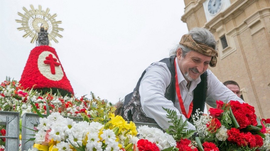 Un hombre compone con flores el manto de la Virgen del Pilar durante la tradicional ofrenda floral a la Virgen del Pilar. EFE. JAVIER CEBOLLADA