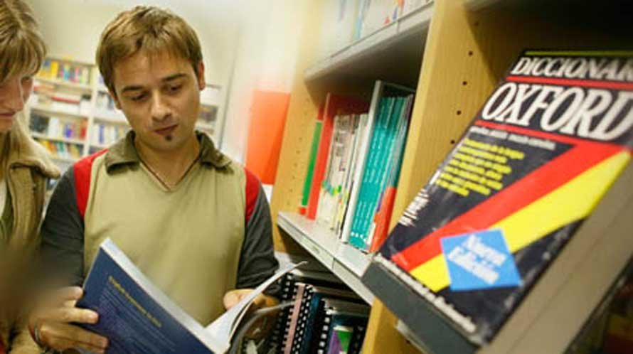 Un estudiante consulta un diccionario de Inglés en la biblioteca. UPNA