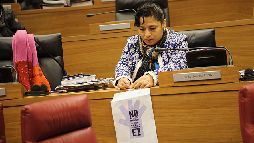La parlamentaria del grupo de podemos Fanny Carrillo coloca un cartel en contra las agresiones sexitas. MIGUEL OSÉS 