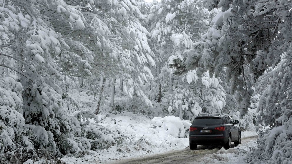 Un coche circula entre la nieve por el Alto de El Perdón en Navarra, comunidad donde la Agencia Estatal de Meteorología mantiene el aviso naranja por nevadas. EFE/Villar López