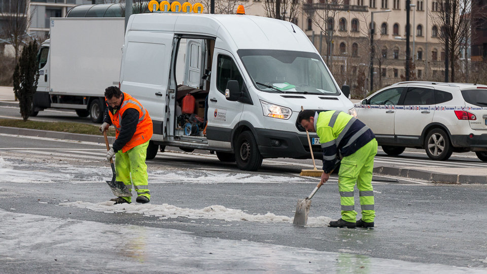 Operarios del Ayuntamiento trabajan para limpiar la vía y arreglar la fuga que ha producido una gran placa de hielo en el cruce entre la Avda. Juan Pablo II y la calle Cataluña. IÑIGO ALZUGARAY