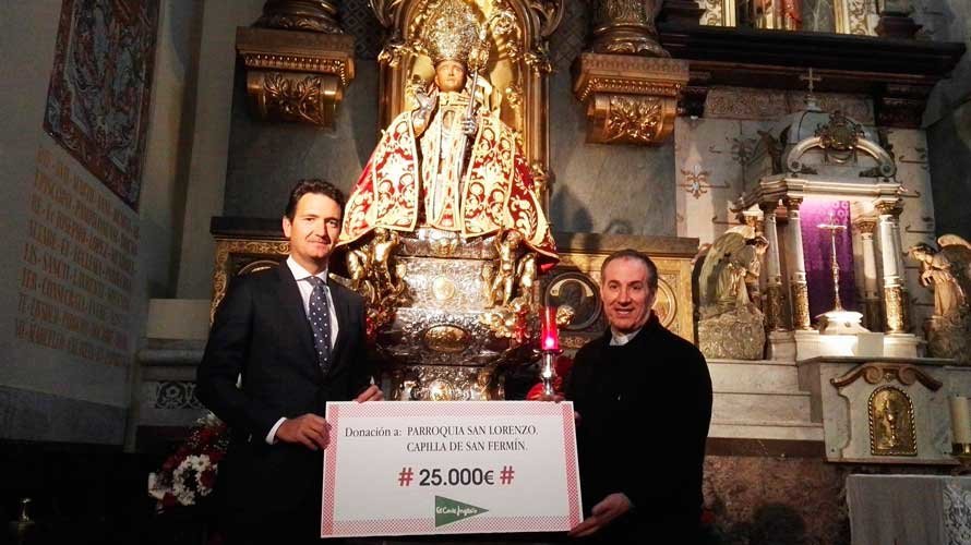 Miguel Bados de El Corte Inglés entrega el cheque a Javier Leoz, párroco de San Lorenzo. EL CORTE INGLÉS