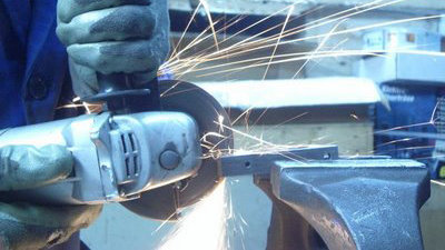 Un hombre manipula una sierra radial entre las chispas que produce al cortal el metal ARCHIVO