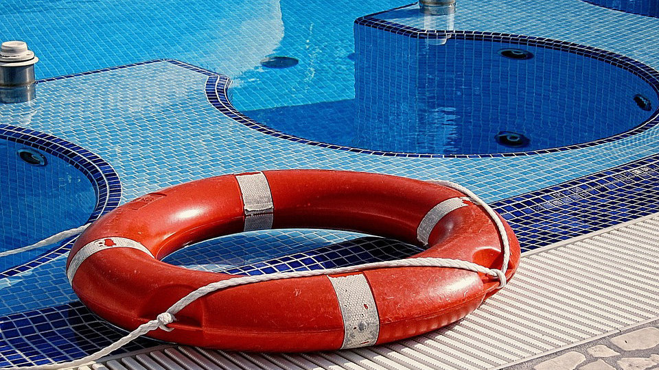 Imagen de un flotador salvavidas en el bordillo junto a una piscina ARCHIVO