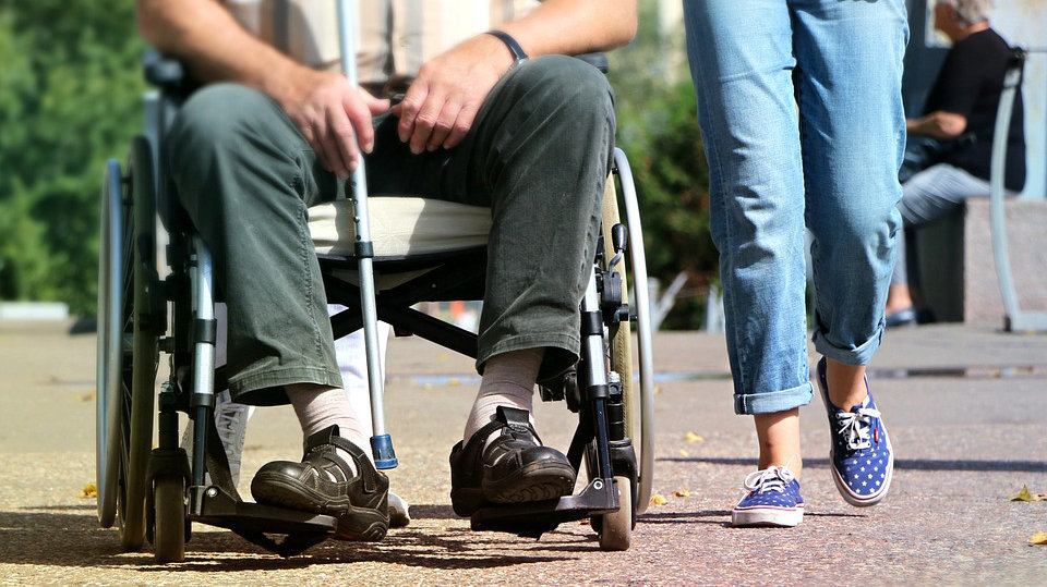Imagen de una persona mayor en sillas de ruedas y llevando una muleta para poder moverse ARCHIVO