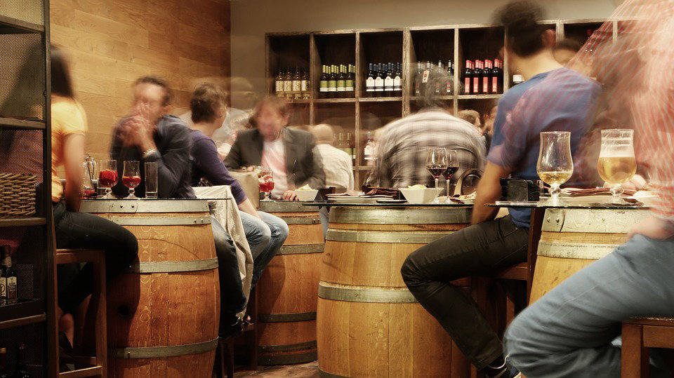 Imagen de varias personas tomando vino y cerveza sobre unos barriles a modo de mesa. ARCHIVO