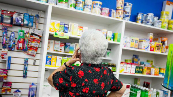 Una mujer busca varios medicamentos en una farmacia EFE