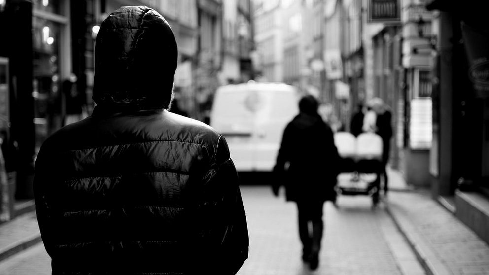 Imagen de un joven encapuchado siguiendo a una mujer por una calle ARCHIVO