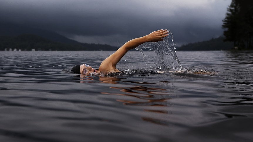 Una persona nadando en un lago.