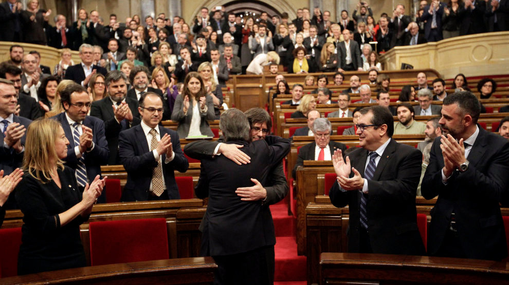El presidente catalán en funciones, Artur Mas (de espaldas), saluda a Carles Puigdemont, poco antes de comenzar el pleno del Parlament. EFE