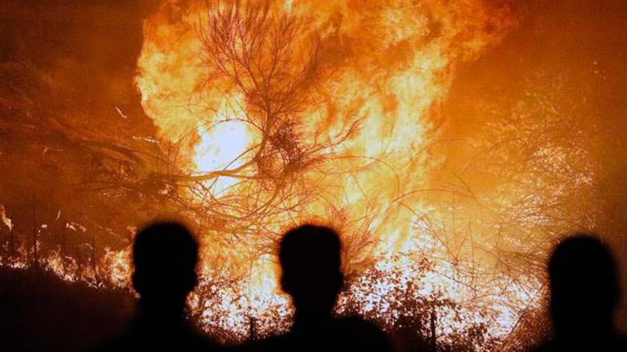 Varias personas observan las fuertes llamas en uno de los incendios que afectan a Galicia. EFE