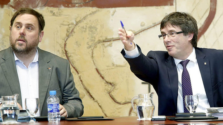 El expresidente de la Generalitat, Carles Puigdemont, y el ex vicepresidente económico, Oriol Junqueras, en una reunión del Ejecutivo EFE