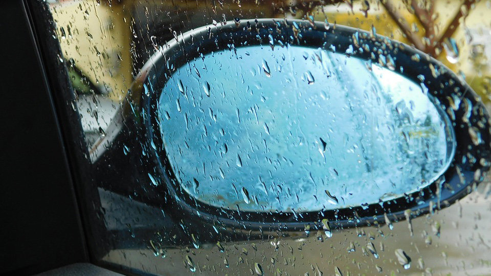 Espejo retrovisor de un coche en una tarde de lluvia.